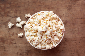 Fototapeta na wymiar popcorn in a bowl top view on a wooden background with place for text