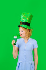 Saint Patricks day or october festival. Beautiful girl in green leprechaun hat drinking green beer....