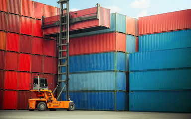 Forklift truck handling cargo shipping container box in logistic shipping yard with cargo container...