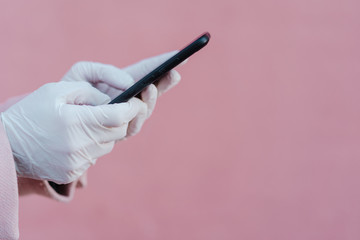 caucasian woman in the street wearing protective gloves and using mobile phone. corona virus concept