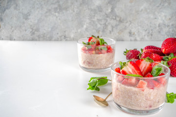 Set various fruit overnight oatmeal. Oats porridge with strawberry, bananas, chocolate, nuts in small portion jars. Summer breakfast oatmeal. Healthy vegan diet snack.