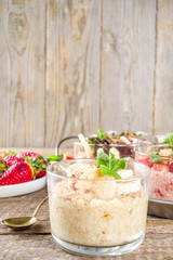 Set various fruit overnight oatmeal. Oats porridge with strawberry, bananas, chocolate, nuts in small portion jars. Summer breakfast oatmeal. Healthy vegan diet snack.
