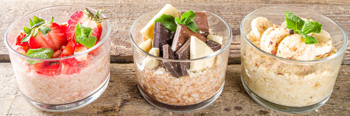 Set various fruit overnight oatmeal. Oats porridge with strawberry, bananas, chocolate, nuts in small portion jars. Summer breakfast oatmeal. Healthy vegan diet snack.