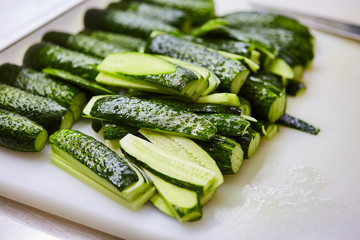 Sliced cucumbers on cutting board. Vegetables ready for salad. Tasty diet Vegetarian food