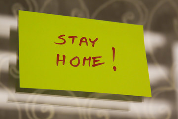 Sticky note on window with Stay Home writing text message
