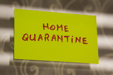 Sticky note on window with Home Quarantine writing text message