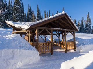 Alpine-style gazebo in a ski resort. Hotel houses in the Siberian camp site. Winter sunny day