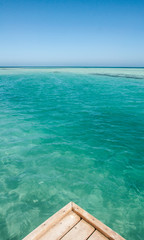Fototapeta premium Blue sky and sea, ocean. A fabulous paradise. Jetty pier on the ocean. Wooden beams in the water. Blue horizon Rest or travel to the sea.