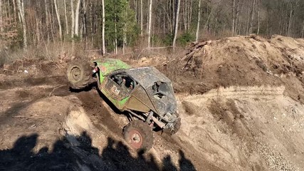 Getting off the beaten path.  Extreme offroad car with huge suspensions at the competition. Car challenge offroad.SUV or offroader on mud road. Offroad car in action. Dirty car drive at high speed.