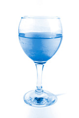 Glass with art blue water on white background. Color of the year concept. Top view, flat lay, copy space. isolated.