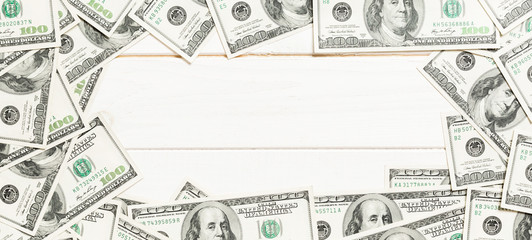 Frame of one hundred dollar bills with empty space for your design. Top view of business concept on white wooden background with copy space