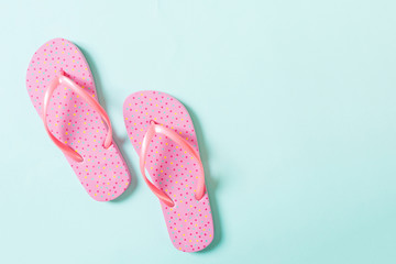 pink flip flops on blue background. Top view with copy space