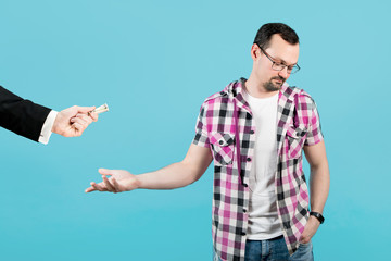 the guy reluctantly agrees to take the money and turns away from the man with the money, Isolated on a blue background