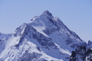 Fototapeta na wymiar Beautiful snow-capped mountain peak under the sunny sky