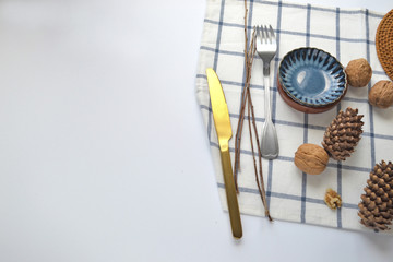 Walnuts, cutlery on a kitchen towel on a white background