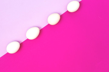 White easter egg on a lilac and rose background, flat lay, copy text