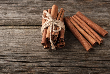 brown cinnamon sticks tied in a bun on a gray wooden background, tasty and fragrant spice