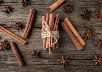 brown cinnamon sticks tied in a bun on a gray wooden background, tasty and fragrant spice