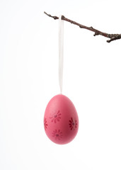 decorative plastic pink easter egg hanging on a branch