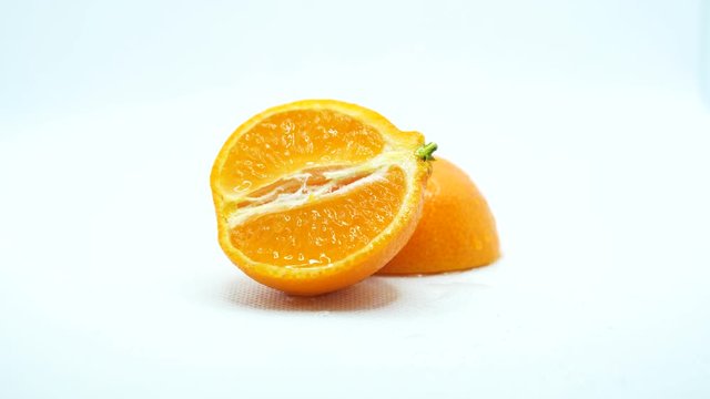 Rotating around fresh sliced orange wet with water drops