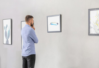 Young man at exhibition in modern art gallery