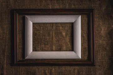 wooden frame on burlap background. space for text.