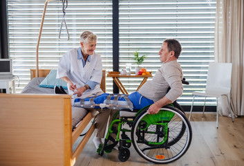 A healthcare worker and paralysed senior patient in hospital.