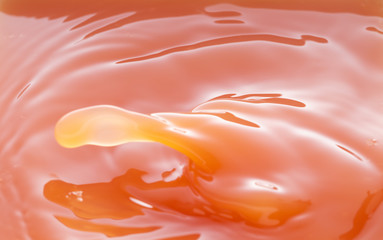 a swirling wave on the surface of grapefruit juice.