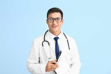 Fototapeta premium Handsome male doctor on color background