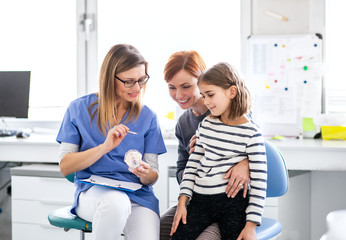 A small girl, mother and dentist in surgery, dental checkup. - Powered by Adobe