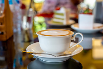 A cup of hot cappuccino coffee in white coffee cup.