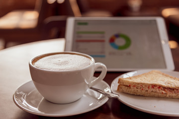 Refreshing and delicious breakfast of businessman with coffee latte, tuna sandwich in coffee shop.