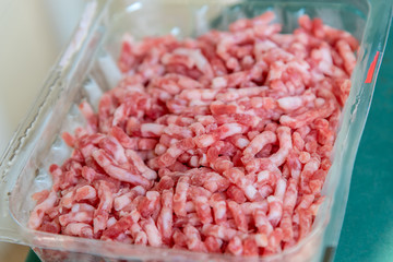 Raw food minced pork meat in plastic package close up image.