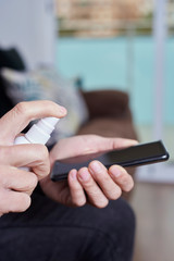 man disinfecting his smartphone.