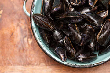 Raw mussels in a blue colander