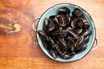 Raw mussels in a blue colander