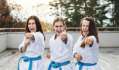 Group of young women practising karate outdoors on terrace. © Halfpoint
