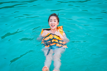 in relaxing time with girl play sea by wearing Life jacket