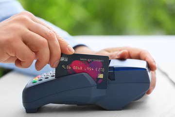 Man using bank terminal for credit card payment, closeup