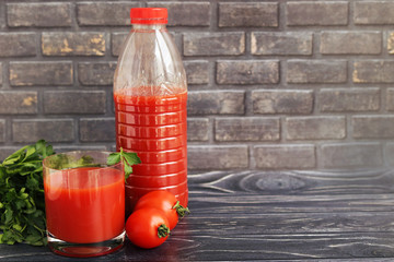Tomato juice in a glass and bottle, space for text