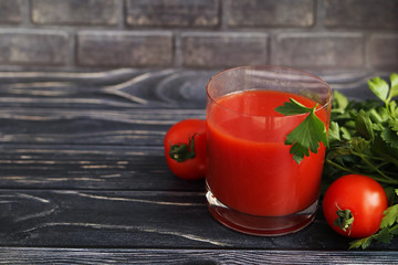 Tomato juice in a glass on a dark wooden background