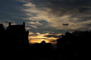 Obraz premium clouds at dusk with the silhouette of a fortified castle