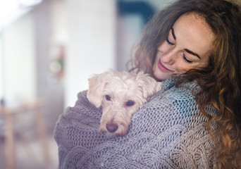 Young woman relaxing indoors at home with pet dog.