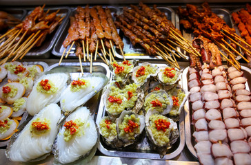Seafood on wooden sticks for grilling.