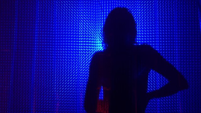 Beauty Model girl dancing shadow silhouette. Beautiful sexy young woman perfect slim body dance in uv light. Silhouette of a girl dancing in the shower behind the curtain