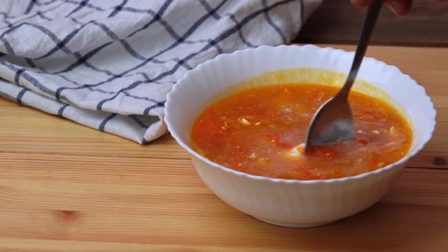 Man eating borsch with sour cream