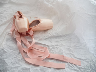 Fototapeta na wymiar Pair of ballet shoe put on grunge surface background,blurry light around