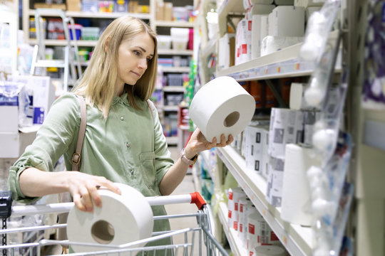 woman buy toilet paper rolls at household goods store
