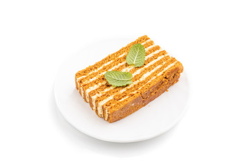 Homemade honey cake with milk cream and mint isolated on white background. Side view.