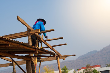 carpenter working on roof structure on construction site.